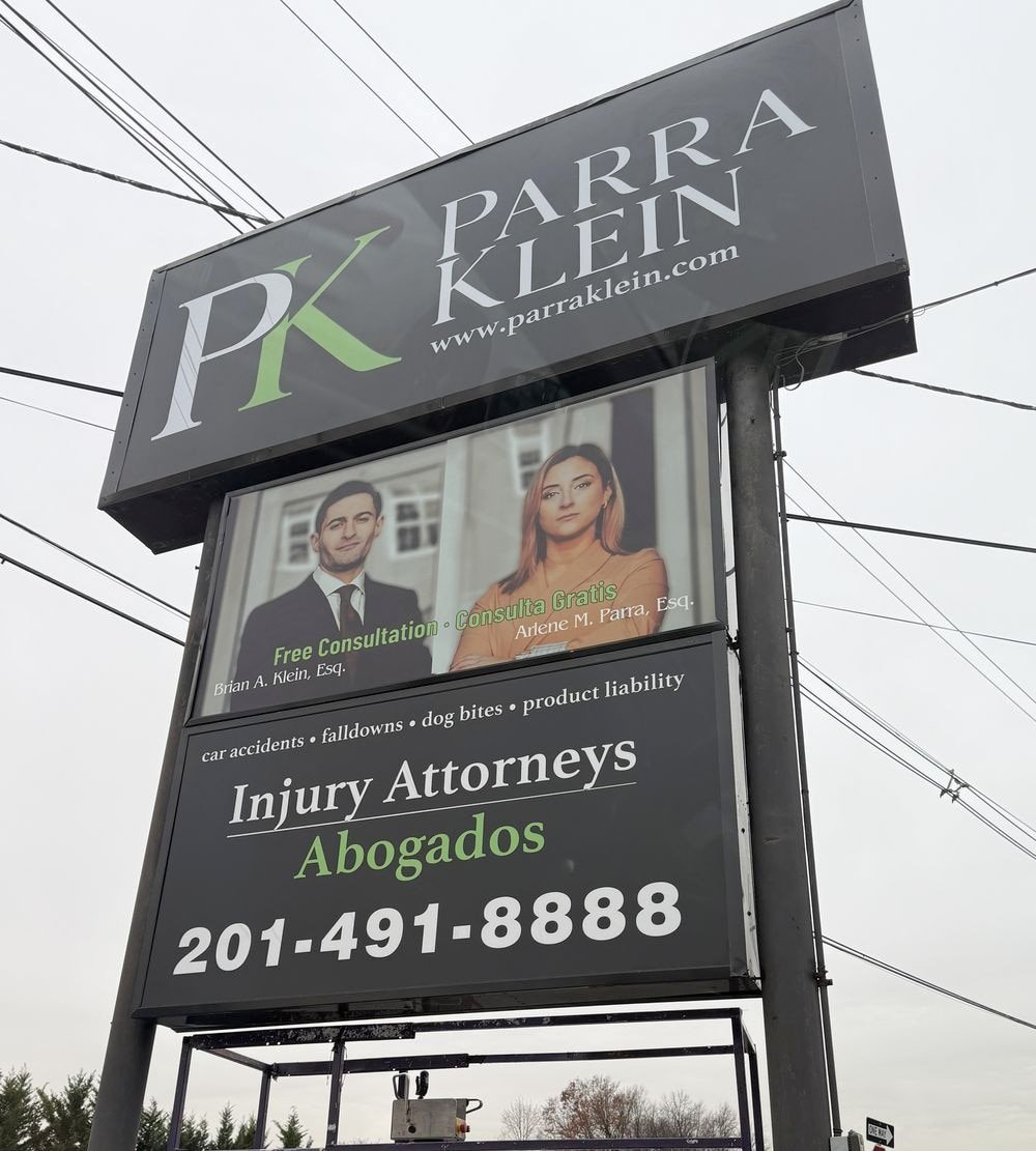 The Parra Klein roadside sign on Route 46 reading Injury Attorneys, Abogados, 201-491-8888